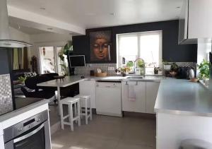 une cuisine avec des placards blancs et une grande fenêtre dans l'établissement Tropical Spirit House, à Marignane