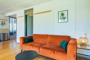 ベルゲン・アーン・ゼーにあるWind - Modern beach houseのリビングルーム(オレンジカウチ、テーブル付)