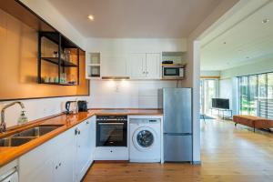 ベルゲン・アーン・ゼーにあるWind - Modern beach houseのキッチン(洗濯機、シンク、食器洗い機付)