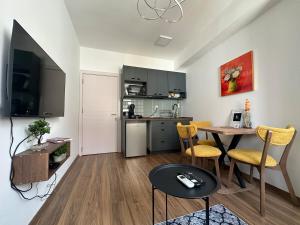 Una sala de estar con cocina y una mesa con sillas. en Moonlight, en Skopje