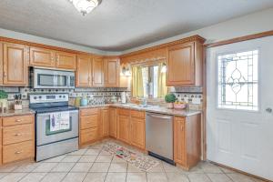una cocina con armarios de madera y una puerta blanca en Game Room, Deck and Fire Pit Covington Township Gem, en Daleville