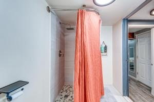 Un baño con una cortina de ducha naranja en una habitación. en Game Room, Deck and Fire Pit Covington Township Gem, en Daleville 30 fotos más