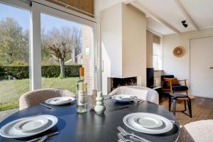 a dining room with a table and chairs and a fireplace at Kiekendief I Gerenoveerd Huisje in Scandinavische Stijl in Zwiggelte