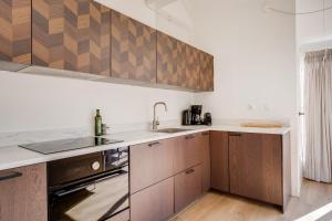 a kitchen with wooden cabinets and a sink at Kiekendief I Gerenoveerd Huisje in Scandinavische Stijl in Zwiggelte