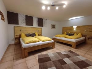two beds in a room with yellow pillows on them at Ferienhaus-Birgit-Gerald-Reinbacher in Gröbming