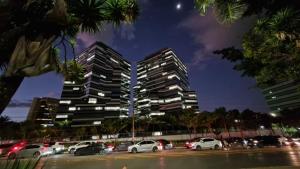 two tall buildings in a parking lot at night at Garvey 1101 - bela vista in Brasilia