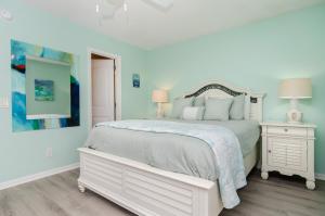 a white bedroom with a white bed and two lamps at A Piece of Heaven by Bryant Real Estate in Carolina Beach +17 photos