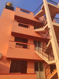 a tall orange building with balconies and a lighthouse at Thiru Somasundaram in Tiruvannāmalai