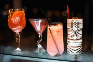 three cocktails on a glass table with at Nireus Hotel in Symi +37 photos