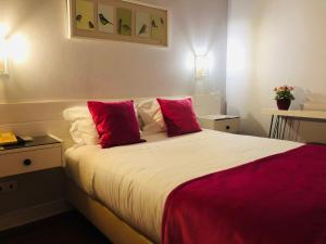 a bedroom with a large bed with red pillows at Hotel Jardim Viana do Castelo in Viana do Castelo