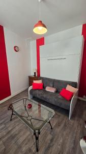 a living room with a couch and a glass table at Le Petit Fleur de Loire in Blois
