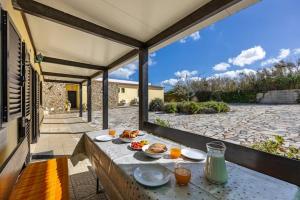 a table with plates of food on a patio at Quinta das AVES - Apartamento T2 com Piscina Comum in Odiáxere