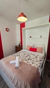 una camera con un grande letto con testiera bianca di Le Petit Fleur de Loire a Blois