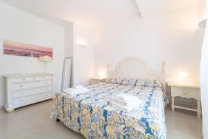 una camera bianca con un letto e due comodini di -Vista Mare e Piscina- Dimora di alta classe per 6 a Liscia di Vacca