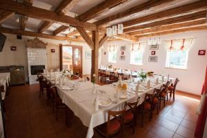 Siedem Drzew في Biskupice: غرفة طعام كبيرة مع طاولات وكراسي بيضاء
