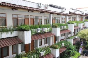 an apartment building with plants on the balconies at Mutiara Hotel and Convention in Bandung