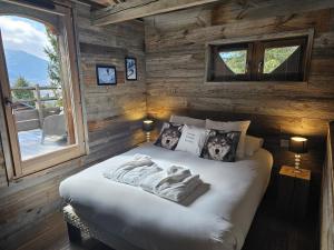 ein Schlafzimmer mit einem Bett in einer Holzwand in der Unterkunft Chalets Collection Greniers D'Alpages - Les Chalets Secrets in Bolquere