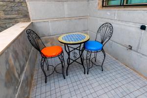 two chairs and a table and a table and chairs at Riad Les Champs De Fès in Fez