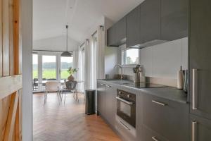 a kitchen with stainless steel appliances and a dining room at Luxe Lodge voor 4 personen met Sauna in Hoogersmilde