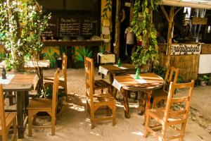 a group of wooden tables and chairs in front of a store at Raiz Hostel in Jericoacoara