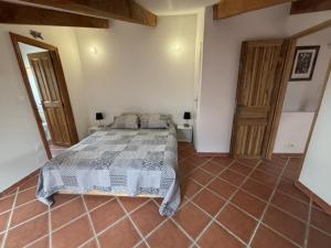 a bedroom with a bed and a tiled floor at La Cheneraie in Artignosc-sur-Verdon
