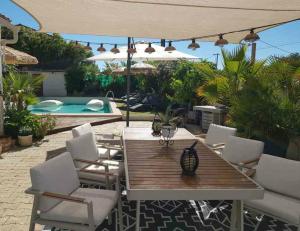 un patio avec une table et des chaises et une piscine dans l'établissement Tropical Spirit House, à Marignane
