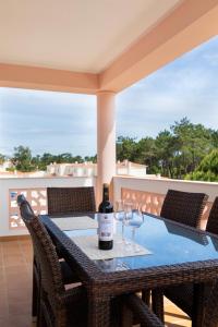 a bottle of wine on a table with wine glasses at T2 espaçoso Praia Del Rey, Óbidos piscina comum, Caravelas in Casal da Lagoa Seca