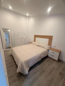 ein Schlafzimmer mit einem Bett, einer Kommode und einem Spiegel in der Unterkunft 4vitas home in Bollullos de la Mitación + 5 Fotos