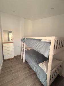 1 Schlafzimmer mit 2 Etagenbetten und einer Kommode in der Unterkunft 4vitas home in Bollullos de la Mitación