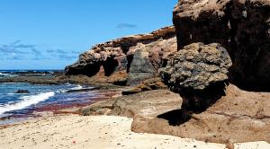 a beach with large rocks and the ocean at Occidental Jandía Mar in Morro del Jable