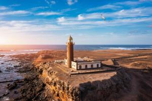 a lighthouse on top of a cliff near the ocean at Occidental Jandía Mar in Morro del Jable