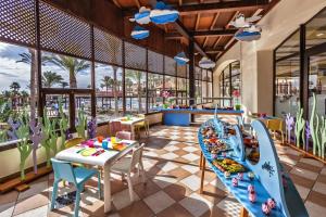 a dining area with tables and chairs and a pool at Occidental Jandía Mar in Morro del Jable