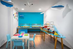 a play room with a table and chairs and a blue wall at Occidental Jandía Mar in Morro del Jable