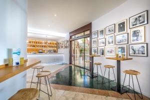 a bar with stools and pictures on the wall at Occidental Jandía Mar in Morro del Jable