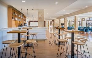 a bar in a restaurant with stools and tables at Occidental Jandía Mar in Morro del Jable