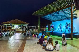 a group of children sitting on the floor watching a show on a stage at Occidental Jandía Mar in Morro del Jable