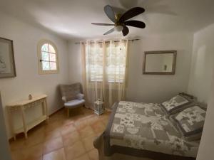 Un dormitorio con una cama y un ventilador de techo. en Maison typique Provençale, en Seillans