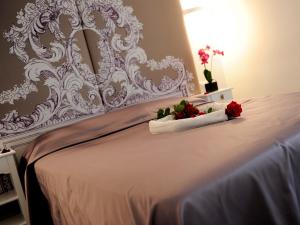 a white bed with two red roses on it at Easyrome Guest House in Rome