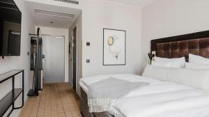 松兹瓦尔Clarion Hotel Sundsvall的卧室里有一张白色的大床和一台电视