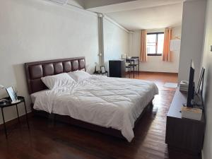 a bedroom with a large bed and a living room at Daisy house pattaya in Jomtien Beach