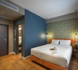 a bedroom with a large bed and a blue wall at The Oscar Olympic Hotel in Thessaloniki