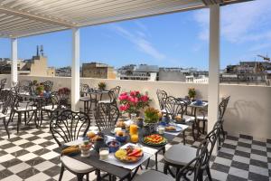 a patio with tables and chairs with food on it at The Oscar Olympic Hotel in Thessaloniki