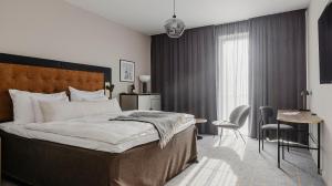 松兹瓦尔Clarion Hotel Sundsvall的一间卧室，配有一张床、一张桌子和几把椅子