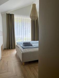 ein Schlafzimmer mit einem Bett und einem Fenster in der Unterkunft MiMi Palanga - Self Check-in in Palanga