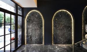 a lobby with three arched windows and black walls at The Oscar Olympic Hotel in Thessaloniki