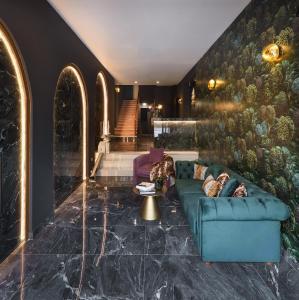 a lobby with a green couch and a staircase at The Oscar Olympic Hotel in Thessaloniki