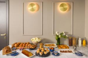 a table filled with different types of bread and pastries at The Oscar Olympic Hotel in Thessaloniki