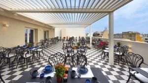 a patio with tables and chairs on a balcony at The Oscar Olympic Hotel in Thessaloniki