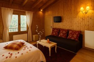 a bedroom with a bed and a couch and a tv at Aithra Boutique Suites in Tsivlós