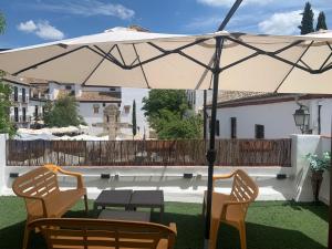 グラナダにあるcasa mirador de san miguelのパティオ(パラソルの下にテーブルと椅子付)